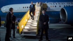 U.S. Secretary of State John Kerry walks down the stairs in the twilight after landing in Vienna, Oct. 22, 2015. 