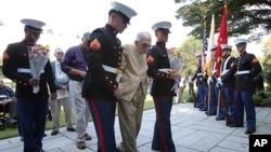 Former American prisoner of war Joseph Demott, 97, center, of Lititz, Pennsylvania, helped by U.S. soldiers, walks to offer flowers at the Commonwealth War Graves in Yokohama, near Tokyo, Oct. 12, 2015.