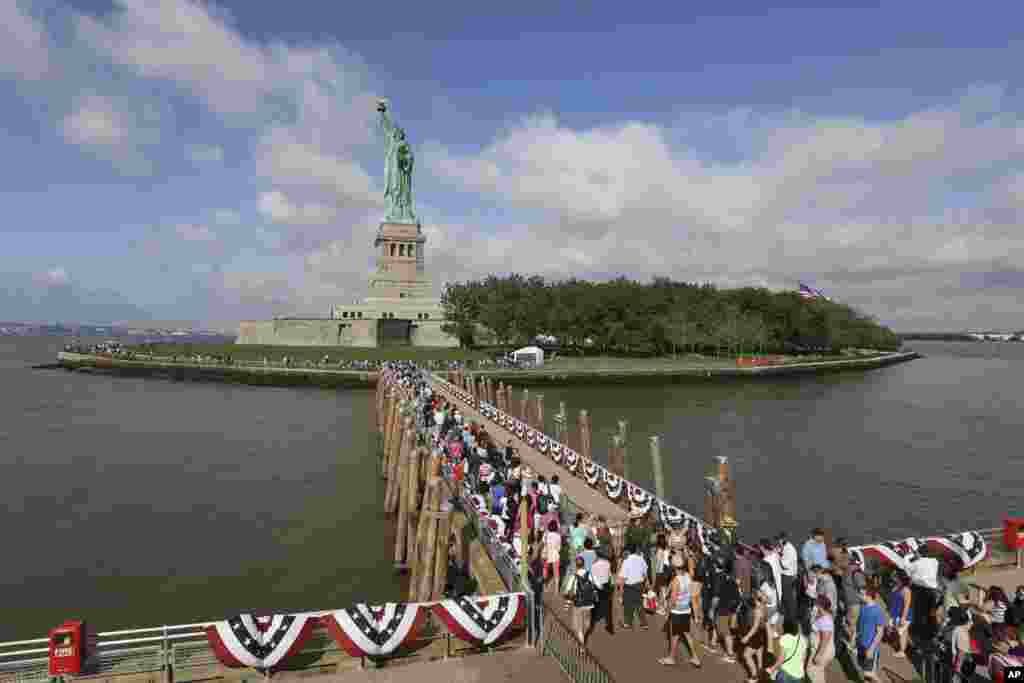 Para pengunjung berjalan menuju Patung Liberty. (AP/Mary Altaffer)