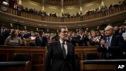 Newly re-elected Spanish Prime Minister Mariano Rajoy, center, is applauded by lawmakers after the second and final confidence vote of the investiture debate at the Spanish Parliament in Madrid, Oct. 29, 2016. 