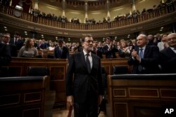 FILE - Newly re-elected Spanish Prime Minister Mariano Rajoy, center, is applauded by lawmakers at the Spanish Parliament in Madrid, Oct. 29, 2016.