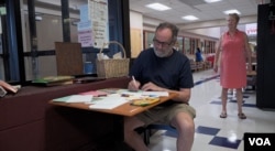 Gettysburg resident Donald Marritz writes a message of encouragement in Spanish for migrant children housed in a Baltimore, Maryland, facility. (M. Kornely/VOA)