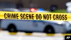 Yellow crime tape blocks off an area where two Baltimore city police officers were shot and a suspect was killed, July 13, 2021, in Baltimore, Maryland. 