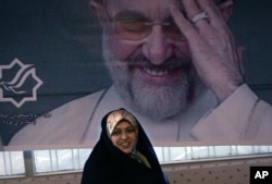 FILE - Sitting under a picture of former Iranian President Mohammad Khatami, Zahra Eshraghi, granddaughter of Ayatollah Ruhollah Khomeini, founder of Iran's 1979 Islamic revolution, looks on in the Youth office of the Coalition of Reformist Groups in Tehran, Iran, March 10, 2008.