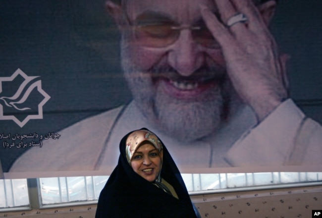 FILE - Sitting under a picture of former Iranian President Mohammad Khatami, Zahra Eshraghi, granddaughter of Ayatollah Ruhollah Khomeini, founder of Iran's 1979 Islamic revolution, looks on in the Youth office of the Coalition of Reformist Groups in Tehran, Iran, March 10, 2008.