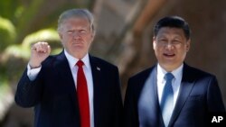 President Donald Trump and Chinese President Xi Jinping pause for photographs at Mar-a-Lago, Friday, April 7, 2017, in Palm Beach, Fla. Trump was meeting again with his Chinese counterpart Friday, with U.S. missile strikes on Syria adding weight to his threat to act unilaterally against the nuclear weapons program of China's ally, North Korea.