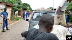 Des cadavres sont disposés à l'arrière d'un pick up alors que la police patrouille dans les rues du quartier Nyakabiga de Bujumbura, le 12 décembre 2015. (AP Photo)