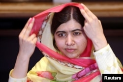 FILE - Nobel Peace Prize laureate Malala Yousafzai adjusts her scarf as she speaks during an interview with Reuters at a local hotel in Islamabad, Pakistan, March 30, 2018.