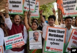 FILE - Members of Bharatiya Janata Party Minority Morcha shout slogans during a protest against the conviction of a retired Indian naval officer Kulbhushan Jadhav, in Mumbai, India.