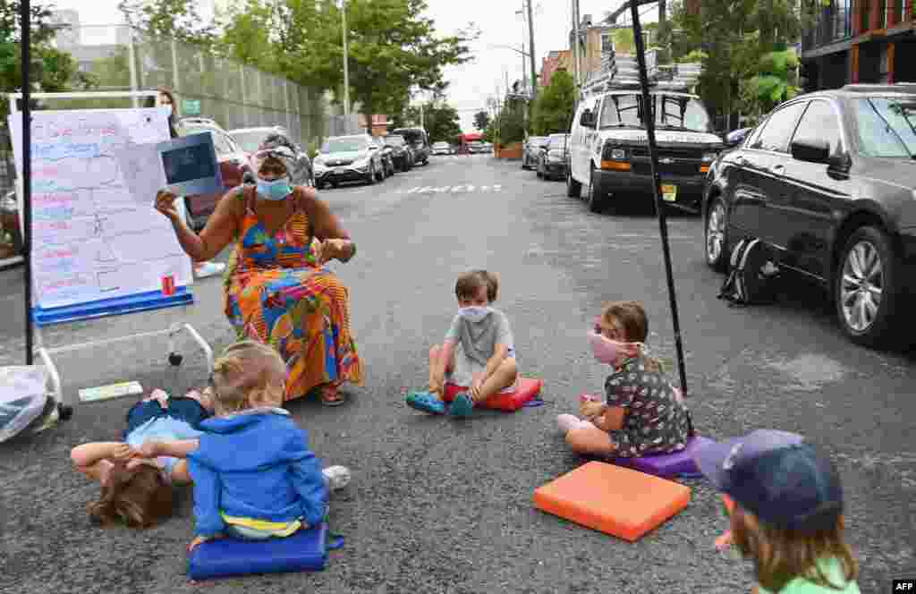 A teacher gives a lesson during an outdoor learning demonstration in front of the Patrick F. Daly public school (P.S. 15) in the Brooklyn area of New York City, Sept. 2, 2020.