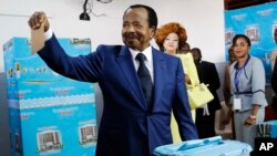 In this Sunday Oct. 7, 2018 file photo, Cameroon's Incumbent President Paul Biya, of the Cameroon People's Democratic Movement party, casts his vote during presidential elections in Yaounde, Cameroon. (AP Photo/Sunday Alamba, File)