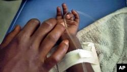A child suffering cholera symptoms receives serum at the hospital in Archaie, 12 Nov 2010