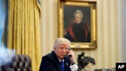 President Donald Trump speaks on the phone with Prime Minister of Australia Malcolm Turnbull in the Oval Office of the White House, Jan. 28, 2017.