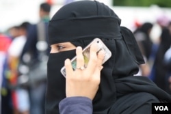 A woman uses a smartphone in Jeddah, Saudi Arabia, Jan. 28, 2016. Saudi Arabia and Iran accuse each other of human rights abuses against their own citizens. International rights groups say both countries have trampled on civil liberties, repressed women and committed other offenses. (H. Murdock/VOA)