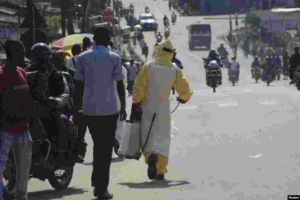 A health worker with disinfectant spray walks down a street outside the government hospital in Kenema, Sierra Leone, July 10, 2014.&nbsp;