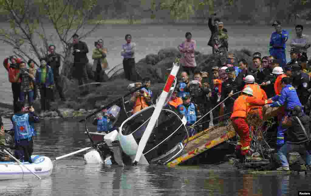 Rescuers pull the wreckage of a small helicopter out of a lake in Hefei, Anhui province, China. The pilot remained missing and the sole passenger was injured after the two-seated Ukraine-made helicopter fell into the lake during during an unregistered flight, local media reported.