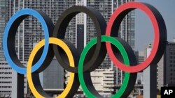 Simbol Olimpiade dipasang kembali setelah diturunkan untuk pemeliharaan menjelang Olimpiade Tokyo 2020 yang ditunda di bagian Odaiba Selasa, 1 Desember 2020, di Tokyo. (Foto: AP/Eugene Hoshiko)