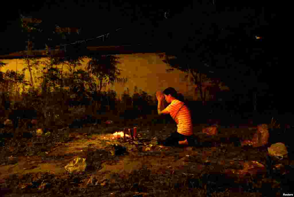 A mother prays outside Maotanchang Middle School in Maotanchang town of Luan, Anhui province, China.