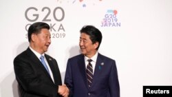 日本首相安倍晉三與中國國家主席習近平在日本大阪出席G20峰會時握手。（2019年6月28日）