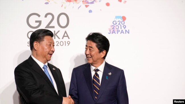 日本首相安倍晋三与中国国家主席习近平在日本大阪出席G20峰会时握手。（2019年6月28日）