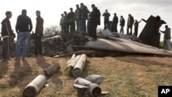 Libyans inspect the wreckage of a US F15 fighter jet after it crashed in an open field in the village of Bu Mariem, east of Benghazi, eastern Libya, March 22, 2011