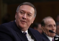 FILE - CIA Director-designate Rep. Michael Pompeo, R-Kan, accompanied by former Senate Majority Leader Bob Dole, testifies on Capitol Hill in Washington, Jan. 12, 2017, at his confirmation hearing before the Senate Intelligence Committee.