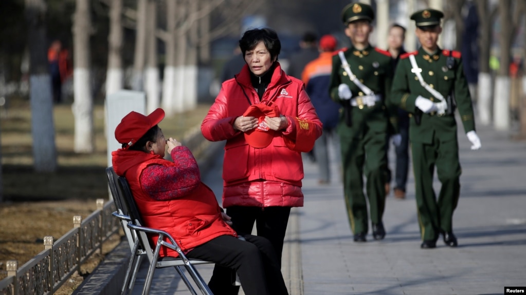 北京长安街旁巡逻的武警和带着红袖章、自称为治安志愿者的北京大妈。（2017年3月2日）(photo:VOA)