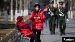 北京長安街旁巡邏的武警和帶著紅袖章、自稱為治安志願者的北京大媽。（2017年3月2日）