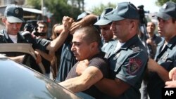 Armenian police detain an unidentified man in Yerevan, Armenia, June 17, 2016. Armed supporters of a jailed opposition leader attacked a police station in Armenia's capital on Sunday.