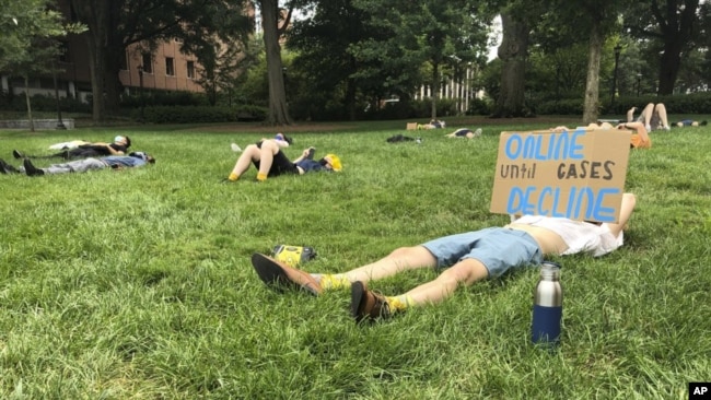 A protester holds a sign opposing in-person classes Monday, August 17, 2020, at a "die-in" at Georgia Tech in Atlanta. (AP Photo/Jeff Amy)