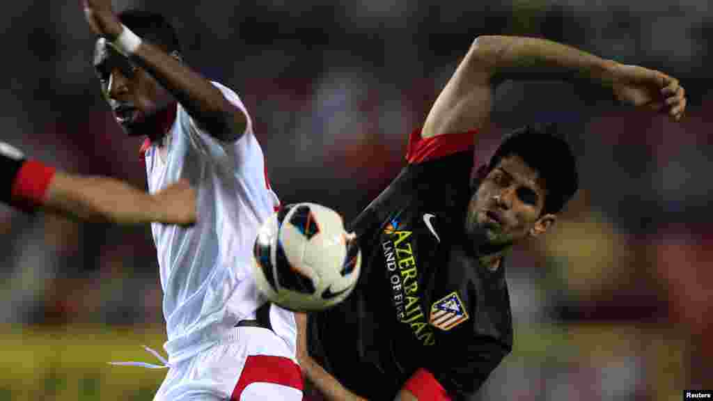 Sevilla's Geoffrey Kondogbia (L) and Atleatico Madrid's Diego Costa battle for the ball during their Spanish First Division soccer match at Ramon Sanchez Pizjuan stadium in Seville April 21, 2013.