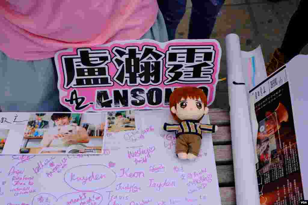 A banner signed by Mirror fans is seen alongside a cartoonized doll of Mirror signer Anso Lo in central London, Sept. 25, 2021. (Kris Cheng/VOA Mandarin)