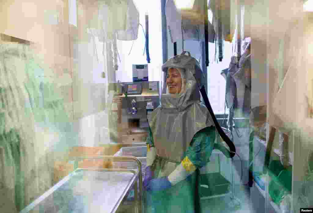 A biologist at the French-Austrian biotech firm Valneva waits before entering a laboratory to work on an inactivated whole-virus vaccine against COVID-19 in Vienna, Austria.