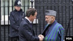 Presiden Hamid Karzai (kanan) disambut oleh PM David Cameron saat tiba di kantor PM Inggris di London (1/3).