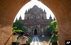 FILE - People watch the Sulamani Guphaya temple, which was damaged after a strong earthquake hit Bagan, Myanmar.