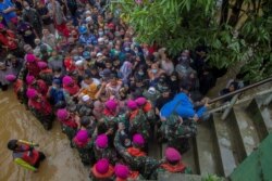 Warga terdampak banjir berkumpul untuk meminta bantuan dari Presiden RI Joko Widodo di Desa Pekauman Ulu, Kabupaten Banjar, Provinsi Kalimantan Selatan, 18 Januari 2021. (Foto: Antara/Bayu Pratama via Reuters)