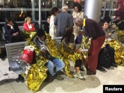 Passengers wrapped in thermal foil blankets given out by emergency services after their Eurostar train was stranded at Calais Station, after intruders were seen near the Eurotunnel, in Calais, France Sept. 2, 2015.