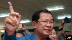 FILE - Cambodian Prime Minister Hun Sen shows off his inked finger after voting in local elections at Takhmau polling station in Kandal province, southeast of Phnom Penh, Cambodia, June 4, 2017.