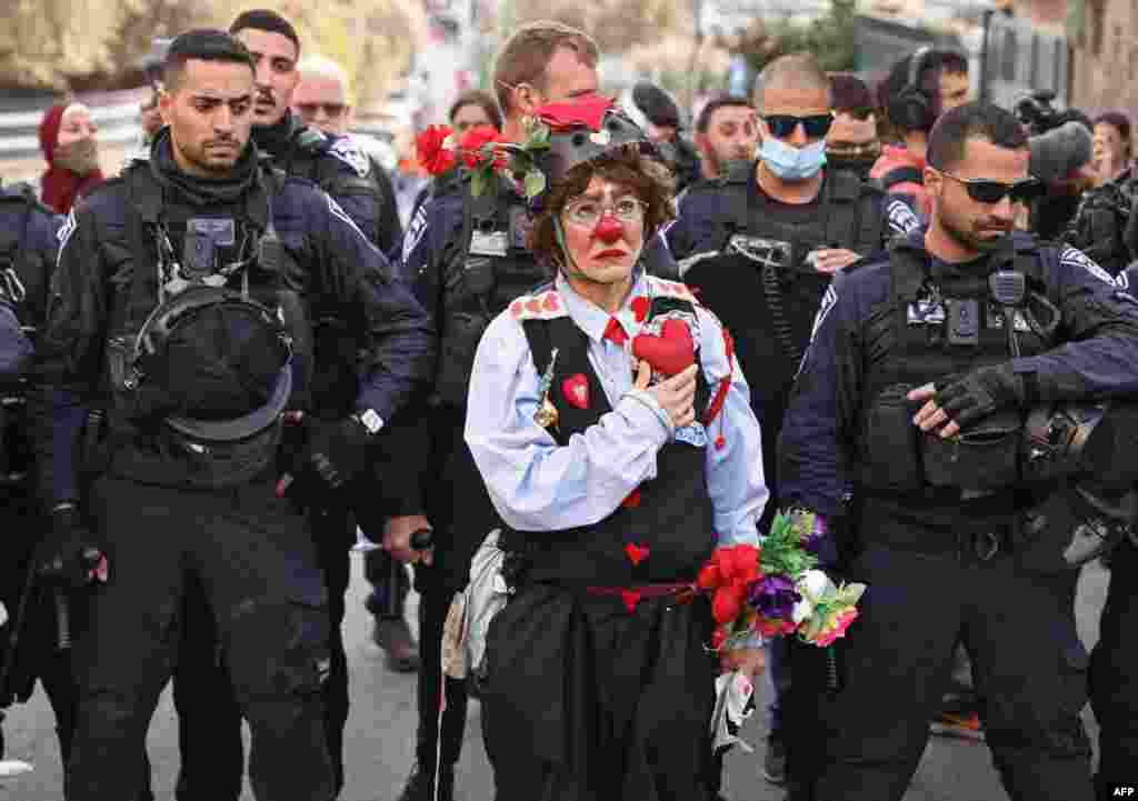 A protester dressed as a clown stands before Israeli policemen during a demonstration in the neighborhood of Sheikh Jarrah in Israeli-annexed east Jerusalem. Hundreds of Palestinians face removal by Israel from homes in east Jerusalem.