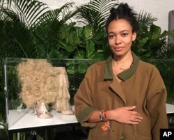 Aurora James, founder of the footwear brand Brother Vellies, poses with a couple of shoe designs inspired by Africa and the superhero film, “Black Panther,” Feb. 12, 2018 in New York.