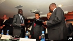 Nhial Deng Nhial, 2nd left, the head of South Sudan's negotiating team, and top negotiator for the rebel's side, Taban Deng Gai, right, a general in South Sudan's army before he defected, sign a cessation of hostilities agreement on Jan. 23, 2014.