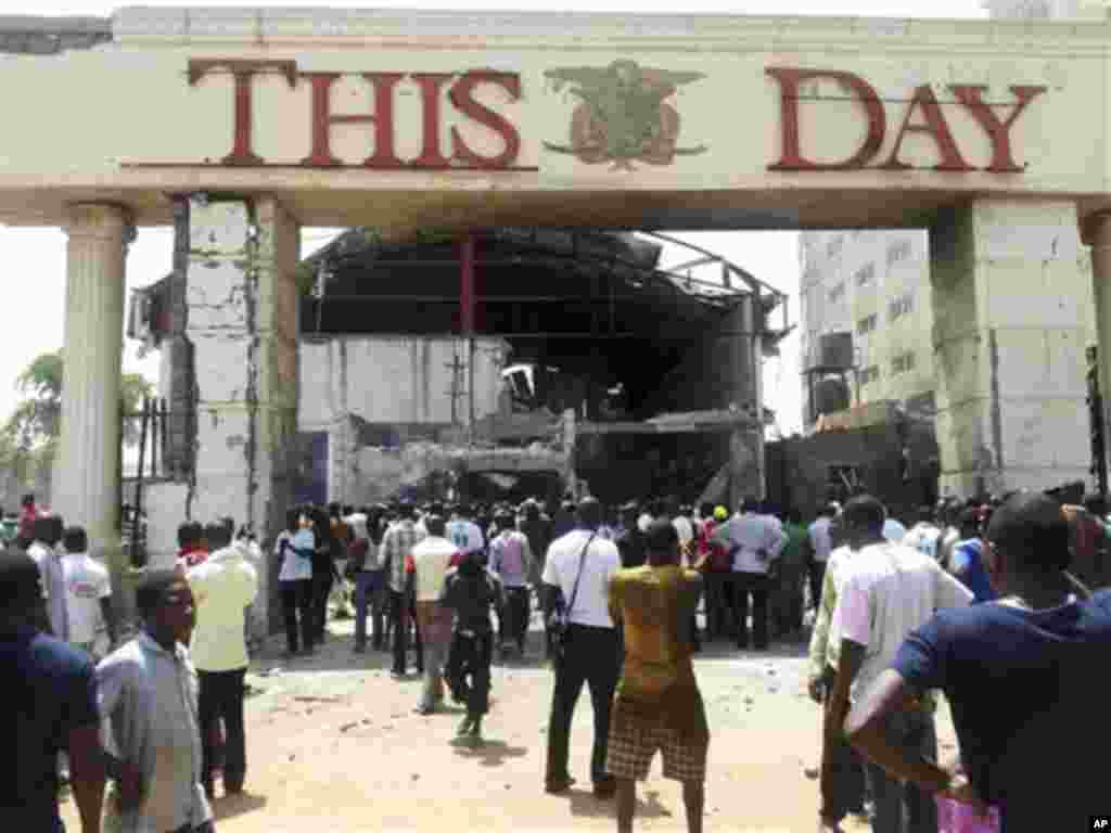 People gather front of the bombed office of ThisDay, an influential daily newspaper in Abuja, Nigeria, Thursday, April. 26, 2012.