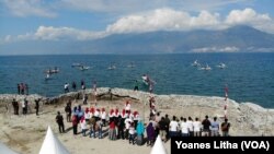 Pelaksanaan upacara bendera Merah Putih di tepi pantai kelurahan Mamboro, Palu Utara, Kota Palu, Sulawesi Tengah oleh relawan Arsitek Komunitas (ARKOM) dan kelompok nelayan, Sabtu, 17 Agustus 2019. (Foto: Yoanes Litha/VOA)