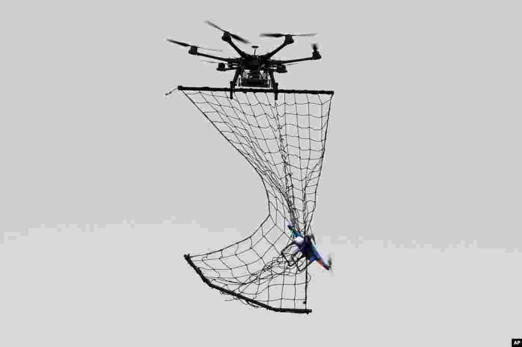A drone Interceptor MP200, top, catches a drone DJI Phantom 2 with a net during a demonstration flight in La Queue-en-Brie, east of Paris, France, Feb. 9, 2015. France has faced dozens of drone overflights over sensitive sites — mostly nuclear facilities, a worrisome development in a country that gets the highest percentage of its energy in the world from atomic power.