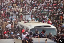 Nigerian presidential candidate Muhammadu Buhari, center, from the All Progressives Congress (APC) party rides atop a bus as he arrives for a party rally in Kano, Jan. 20, 2015.