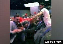 A supporter of Turkish President Recep Tayyip Erdogan attacks a protester who interrupted Erdogan's speech at a New York hotel, Sept. 21, 2017.