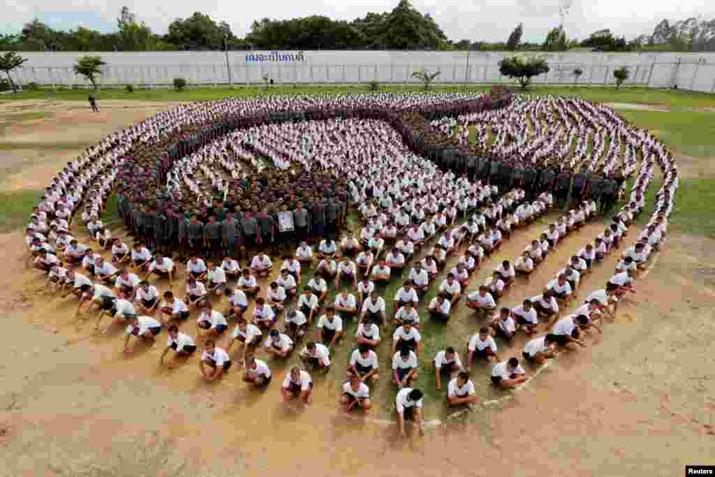 Male inmates form the Thai symbol for the number nine, to honor late Thai King Bhumibol Adulyadej at the Central Correctional Institution for Young Offenders in Pathum Thani province, on the outskirts of Bangkok,Thailand.