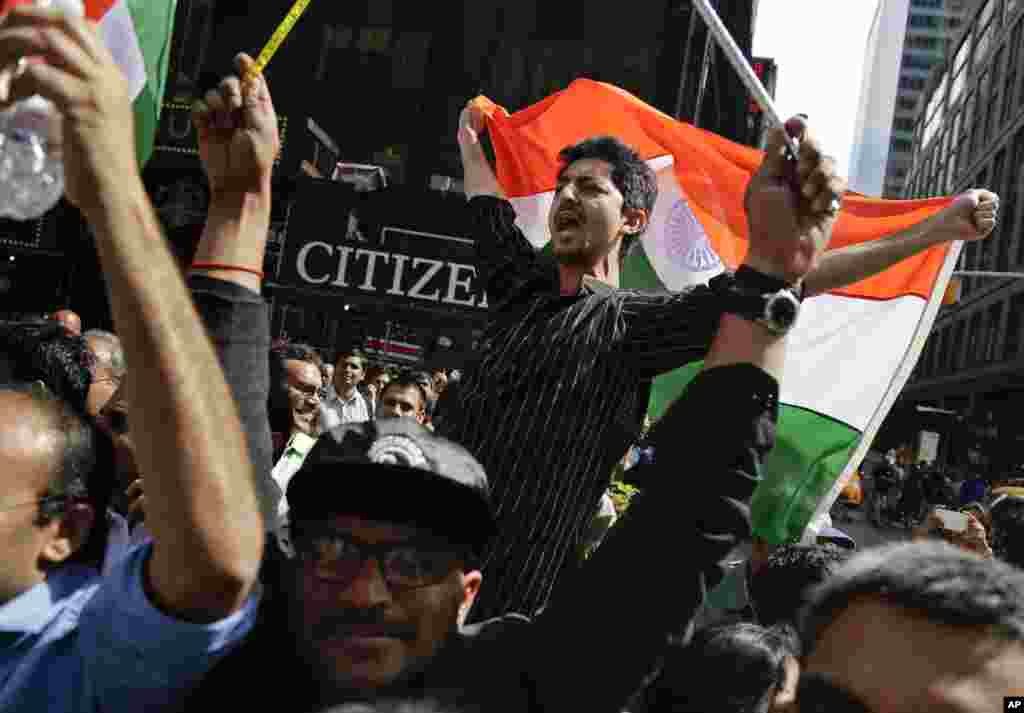 Supporters of Indian Prime Minister Narendra Modi shout slogans as they watch a live stream of Modi's speech from Madison Square Garden, in Times Square, New York, Sept. 28, 2014.