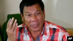 FILE - Presumed Philippine president-elect Rodrigo Duterte gestures during a news conference.