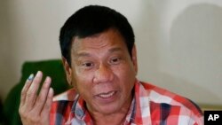 Front-running presidential candidate Mayor Rodrigo Duterte gestures during his second news conference after voting in a polling precinct at Daniel R. Aguinaldo National High School, Matina district, his hometown in Davao city in southern Philippines, May